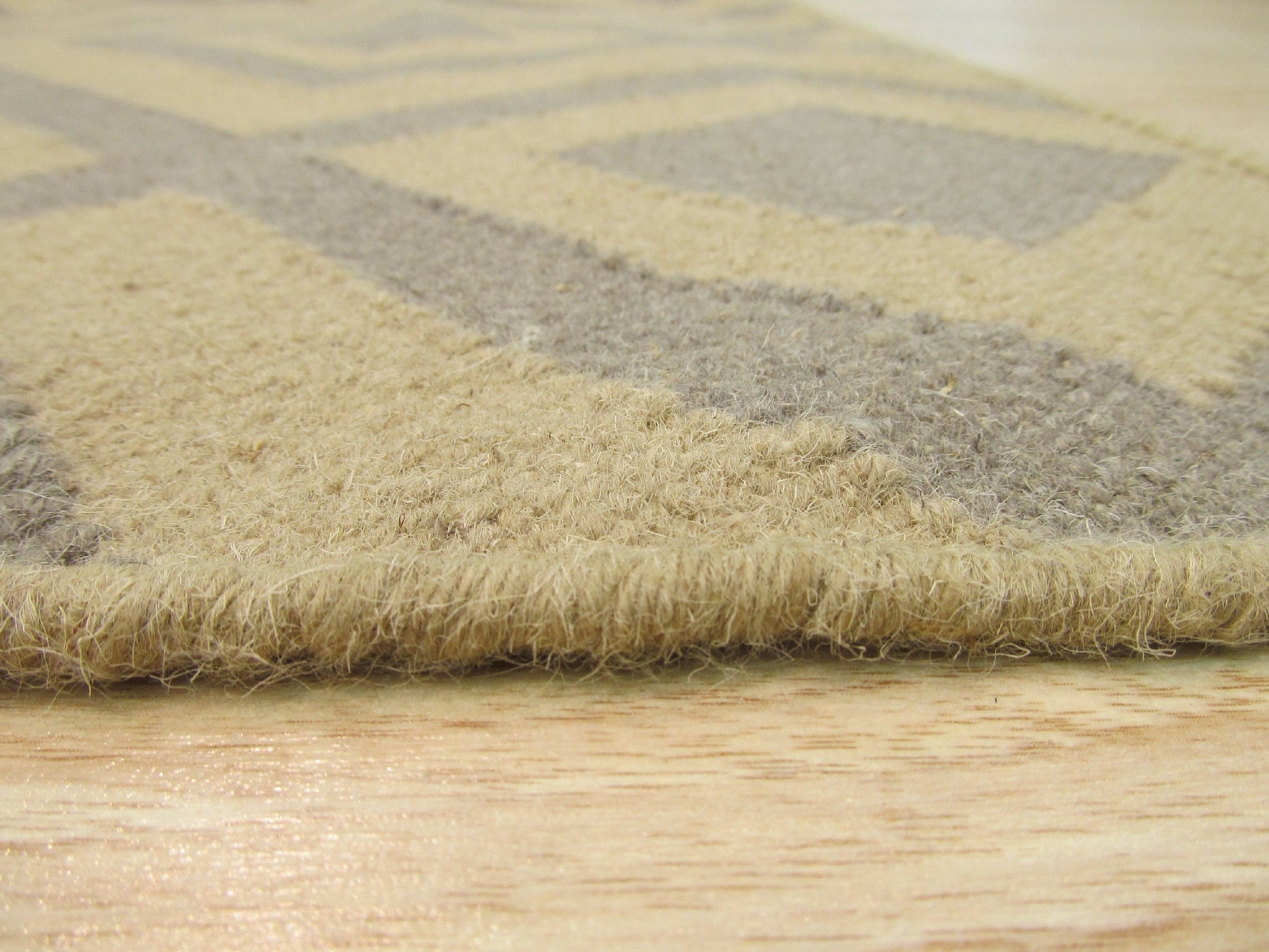 Quinn Kilim Beige Flatweave Wool Rug, showcasing its neutral beige tones and flatweave construction within a warmly lit interior, suggesting a versatile and subtly textured foundation for any room.