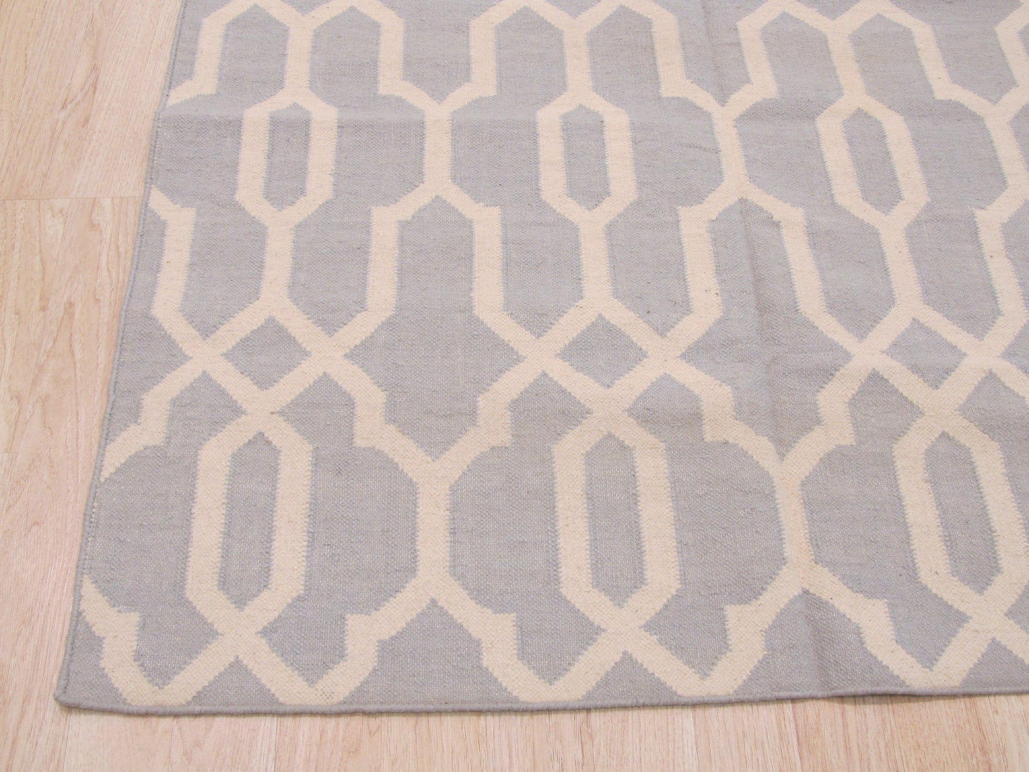 Chloe Trellis Blue Flatweave Wool Rug, showcasing a light and airy space featuring a blue trellis patterned rug with flatweave construction, anchoring a seating area with neutral furniture and ample natural light.