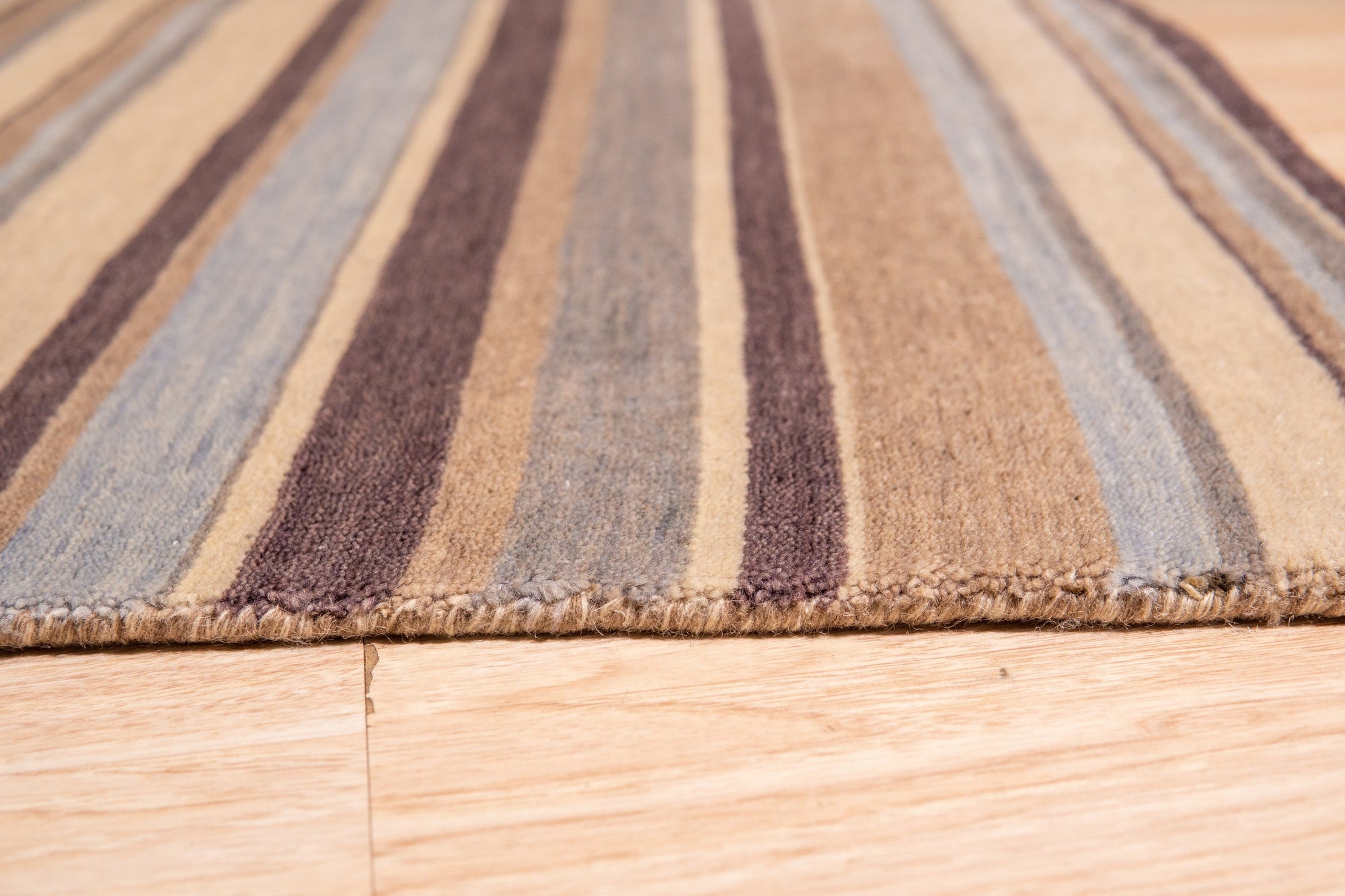 Luxurious Willow Multicolor Handmade Wool Rug displayed on a light wood floor, showing its vibrant blend of colors and textured wool construction.