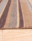 Luxurious Willow Multicolor Handmade Wool Rug displayed on a light wood floor, showing its vibrant blend of colors and textured wool construction.
