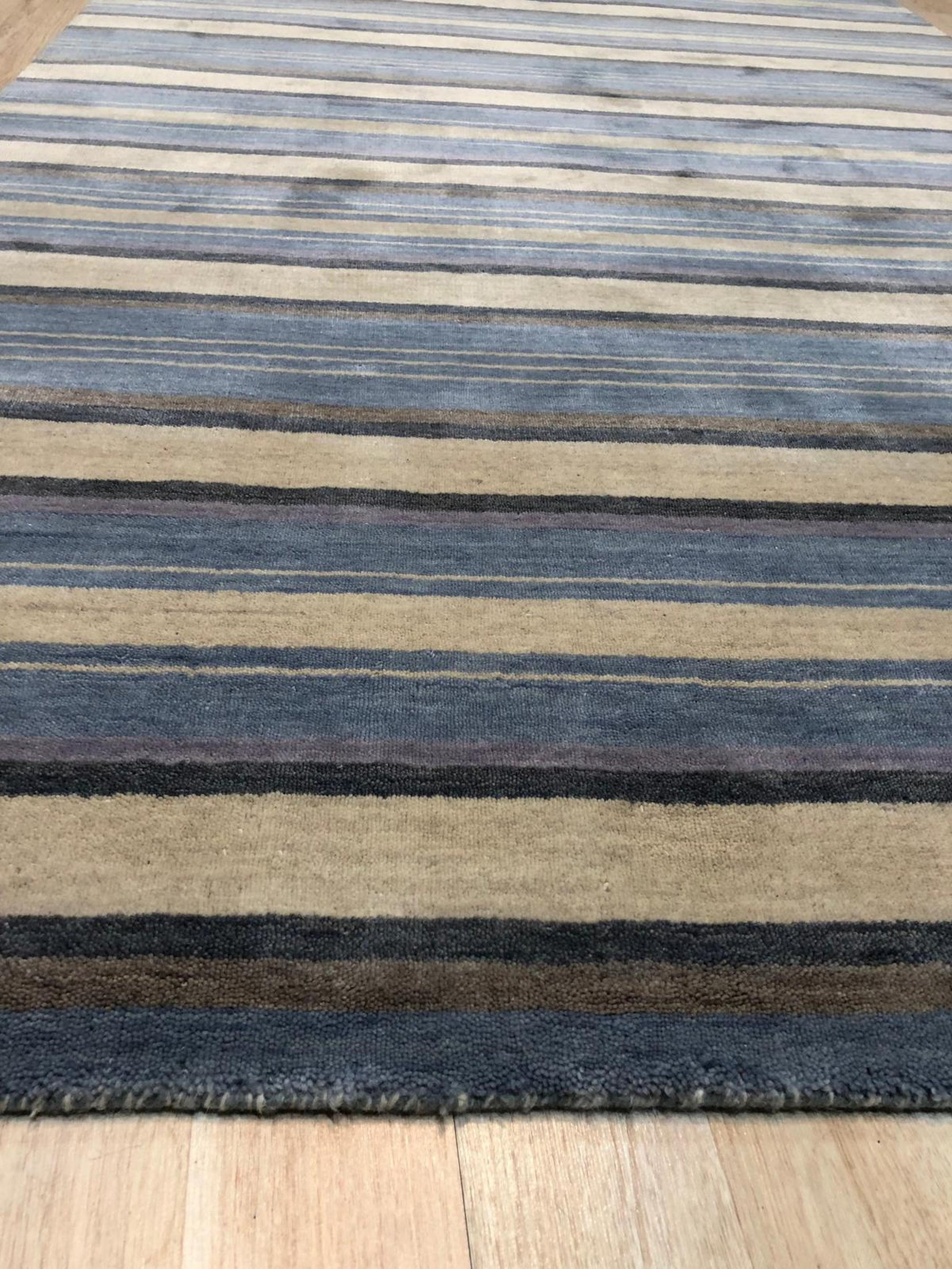 Trendy Classic Multicolor Handmade Wool Rug displayed on a light wood floor, its vibrant, geometric pattern adding warmth to the modern space.
