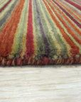 Lush Striped Red Flatweave Wool Rug anchoring a living space, its bold red stripes adding warmth and texture to the scene. Flatweave construction apparent in the tightly woven wool fibers.