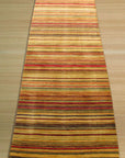 Lush Striped Red Flatweave Wool Rug, presenting bold red stripes against a neutral backdrop in a bright, airy living space. The flatweave wool construction offers a textured, yet low-profile, layer to the room.