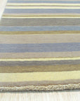 Ella Rustic Brown Handmade Wool Rug, showcasing warm, earthy tones and hand-woven texture, complements a modern living room setting with a neutral sofa and wooden accents.