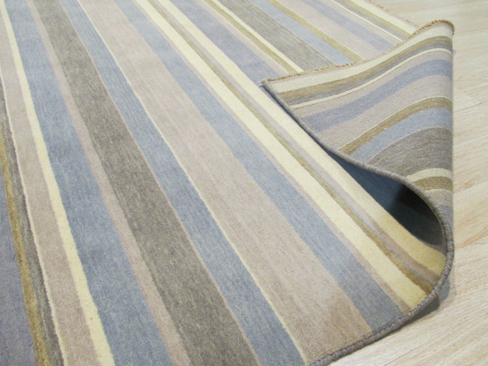 Ella Rustic Brown Handmade Wool Rug, its warm, rustic brown tones and textured wool construction grounding a cozy living space with neutral furniture and natural light.