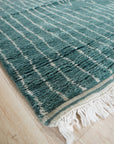 Hand-knotted texture of the Beautiful Celia Green Hand Knotted Wool Rug fills the frame, showcasing its intricate weave and vibrant green hues. Wool fibers catch the light, highlighting the rug's plush pile and detailed design.