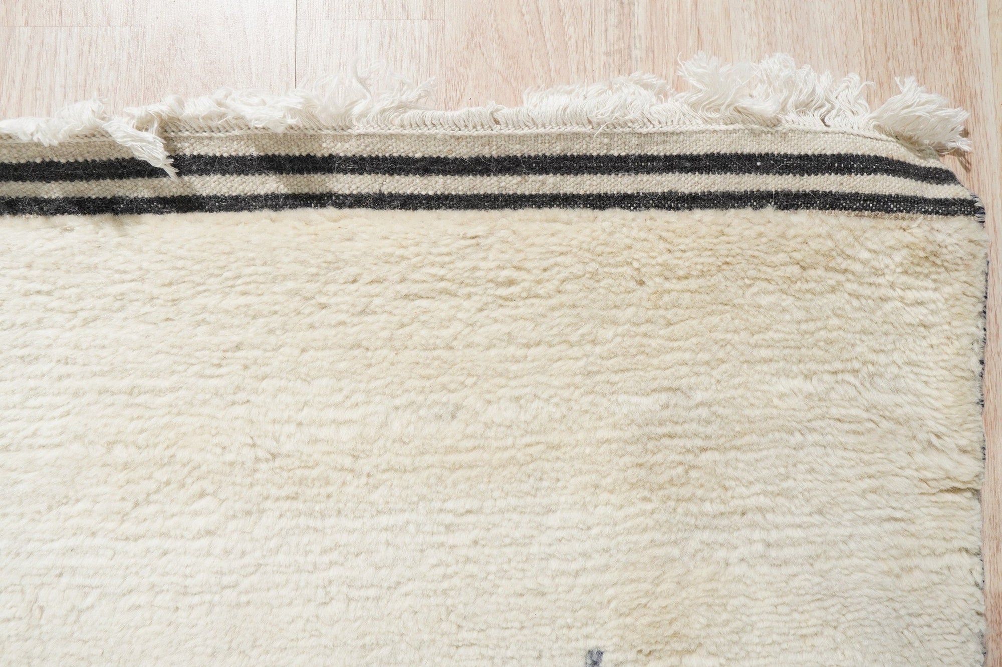Selene Moroccan Ivory Hand Knotted Wool Rug, a luxurious textured weave in a bright, airy living room setting.
