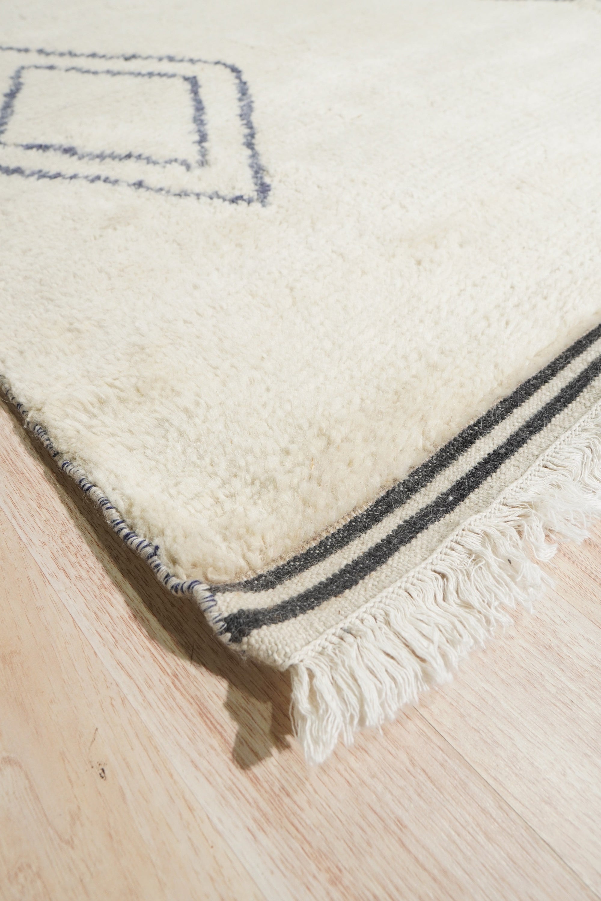 Selene Moroccan Ivory Hand Knotted Wool Rug, a textured expanse of ivory wool with subtle geometric patterns, grounds a bright, modern living space.