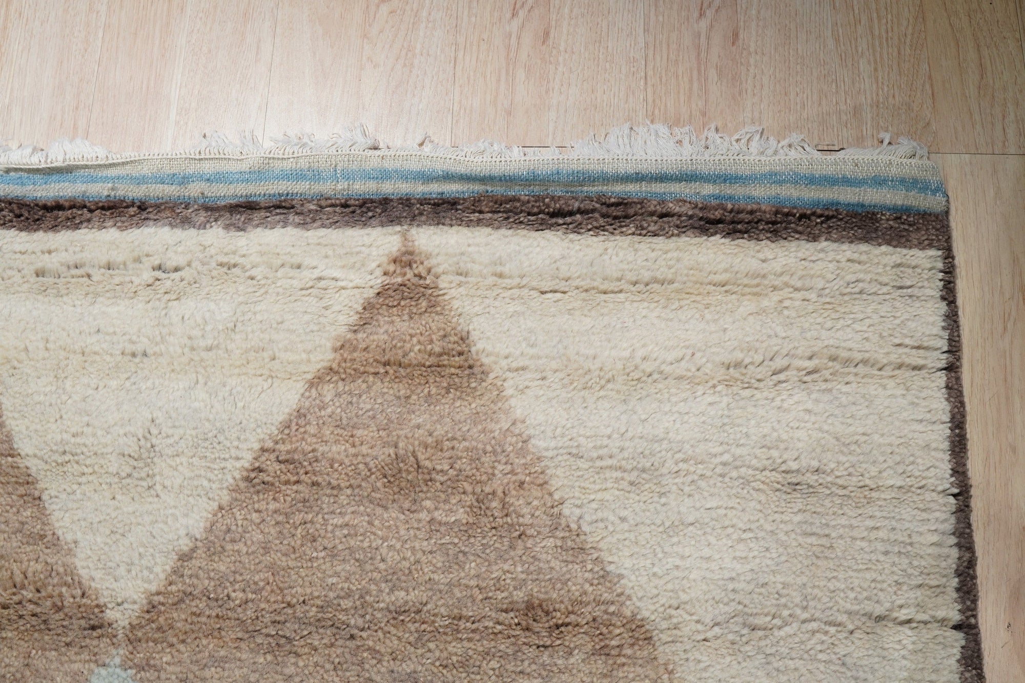 Comfortable Moroccan Multicolor Hand Knotted Wool Rug, a vibrant wool rug showcasing a lively mix of colors and a traditional Moroccan design, lies gracefully on a light wood floor.