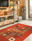 Classic Artisan Red Machine Made Wool Rug, showcasing its intricate floral medallions and borders in warm red hues, layered over a light wooden floor in a bright, inviting living room.