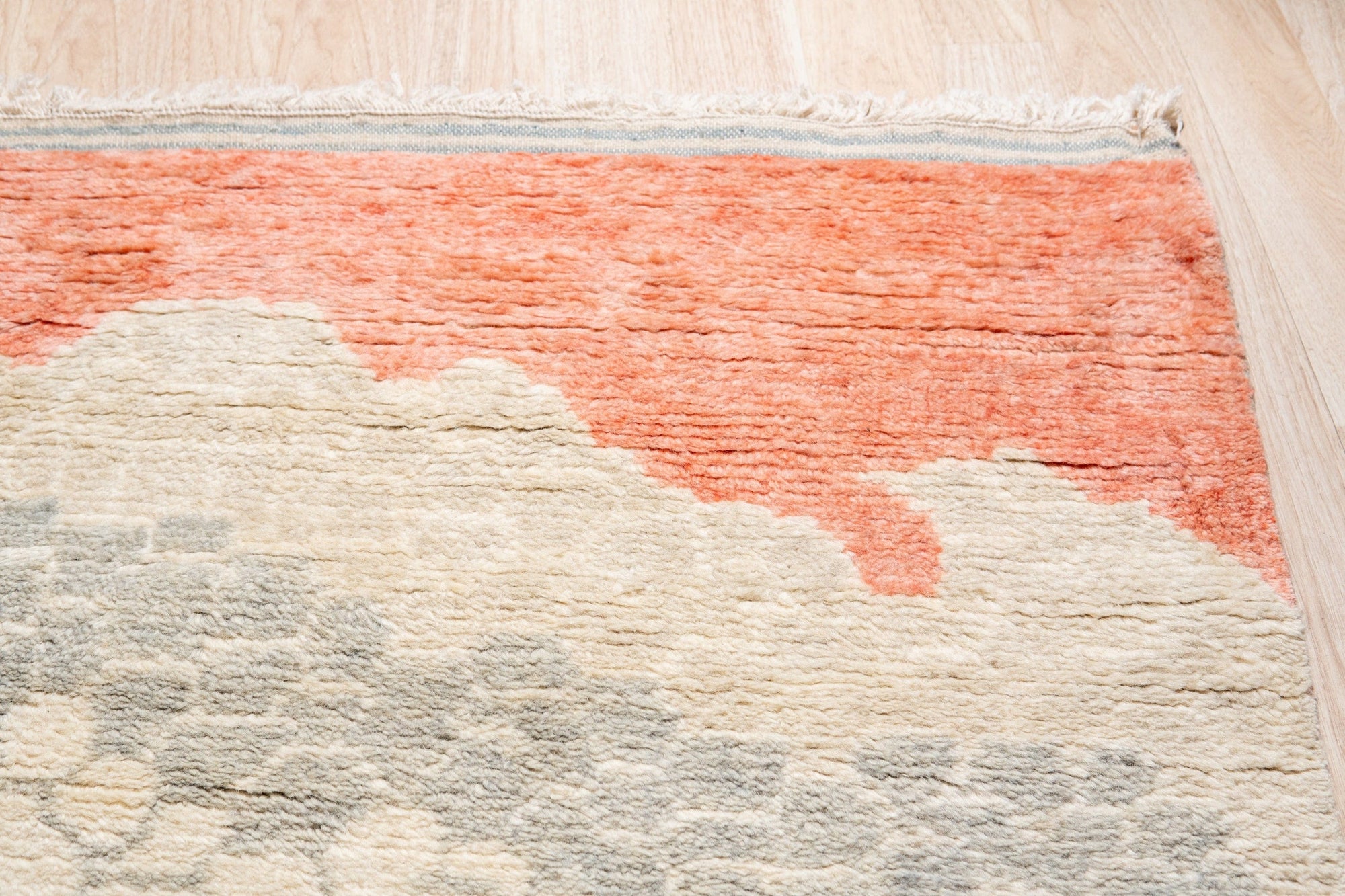 Comfortable Moroccan Multicolor Hand Knotted Wool Rug, a vibrant symphony of earthy tones and geometric patterns, lending a cozy, artisanal feel to a bright, minimalist interior.