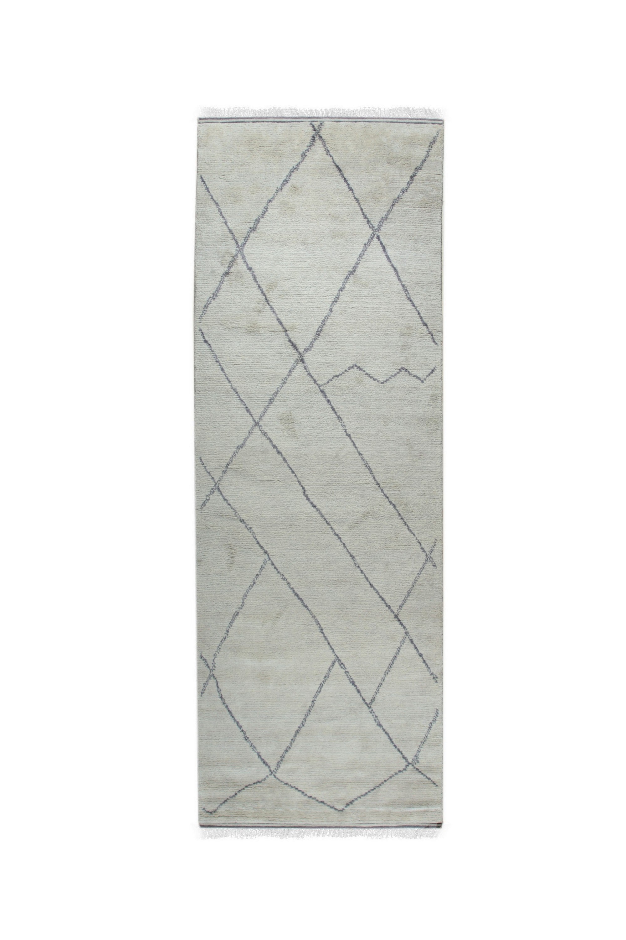 Penelope Diamond Silver Hand Knotted Wool Rug, showcased in a bright, airy living room setting. Its subtle silver and neutral tones complement the modern furniture, highlighting the intricate hand-knotted diamond pattern across the soft wool fibers.