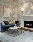 Penelope Diamond Silver Hand Knotted Wool Rug, a silver wool rug with a diamond pattern, seen in a bright living room setting under a coffee table, showcasing its intricate hand-knotted construction.