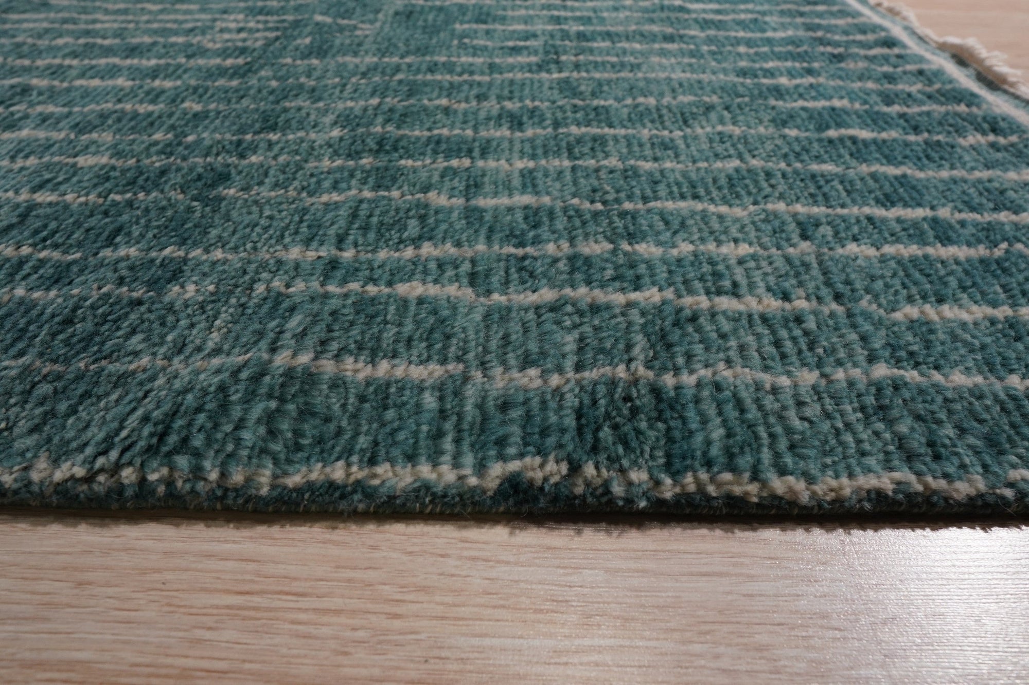 Lush Moroccan Green Hand Knotted Wool Rug, a vibrant, emerald green wool rug with intricate Moroccan-inspired knotwork, filling a bright, modern living room.