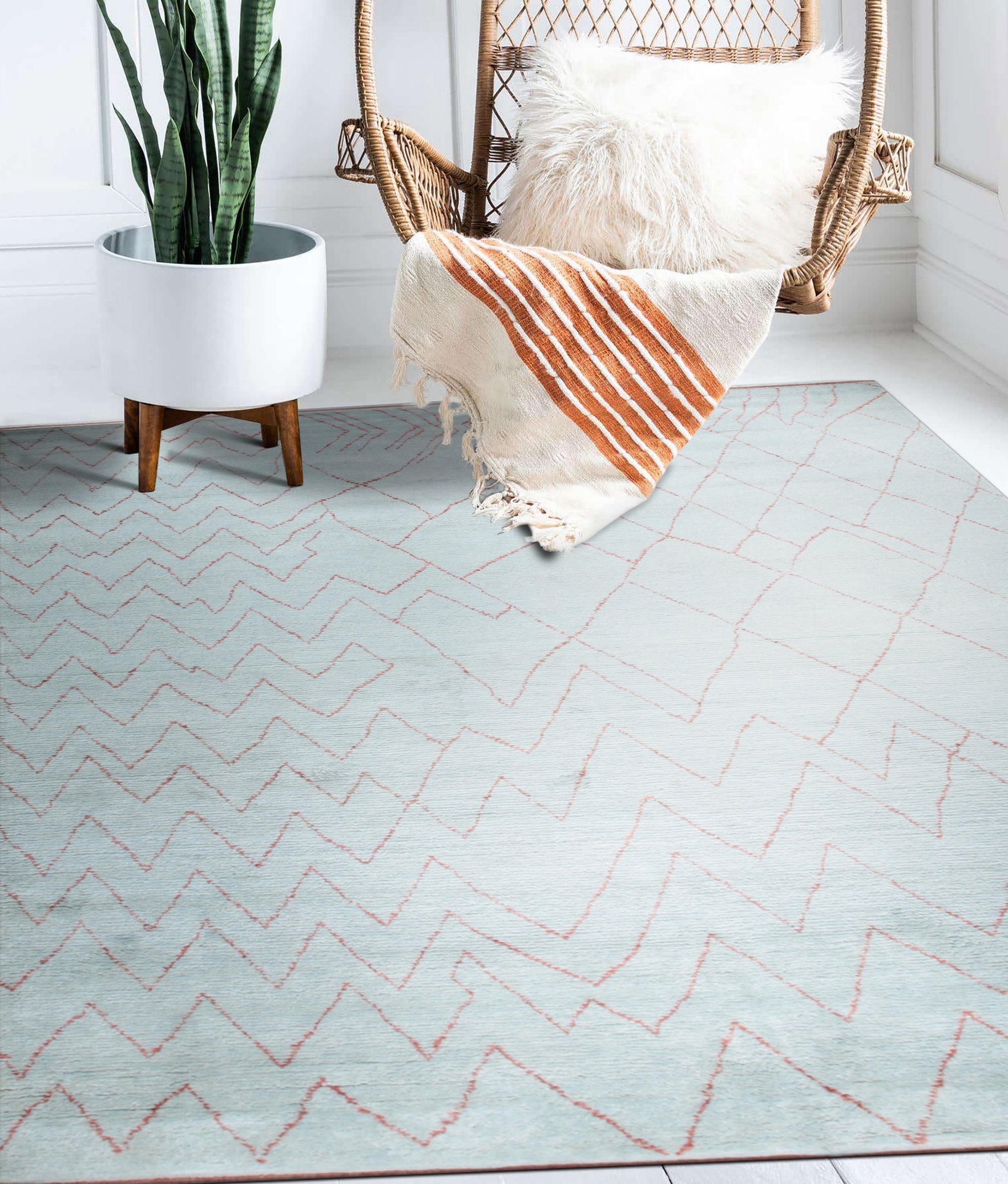 Isla Moroccan Light Blue Hand Knotted Wool Rug displayed in a bright, neutral living room setting. Light blue and cream hues complement the surrounding decor, highlighting the rug's intricate hand-knotted wool construction and classic Moroccan design.