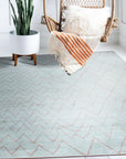 Isla Moroccan Light Blue Hand Knotted Wool Rug displayed in a bright, neutral living room setting. Light blue and cream hues complement the surrounding decor, highlighting the rug's intricate hand-knotted wool construction and classic Moroccan design.