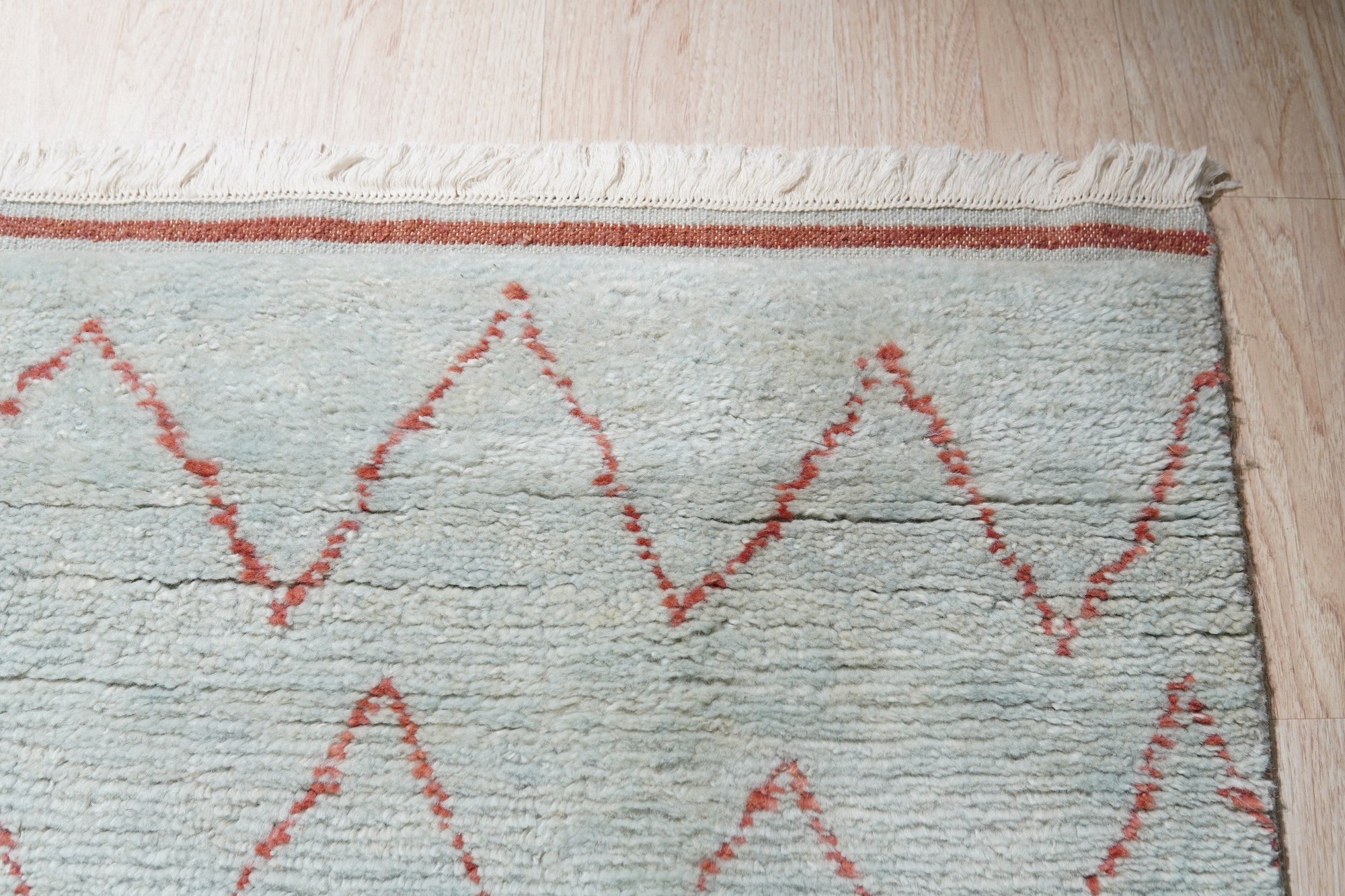 Isla Moroccan Light Blue Hand Knotted Wool Rug, a light blue hand-knotted wool rug with a traditional Moroccan design, seen in a bright, contemporary living room setting.
