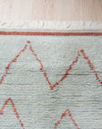 Isla Moroccan Light Blue Hand Knotted Wool Rug, a light blue hand-knotted wool rug with a traditional Moroccan design, seen in a bright, contemporary living room setting.