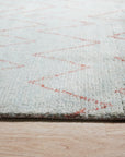 Isla Moroccan Light Blue Hand Knotted Wool Rug, bathed in soft light, features a subtle, geometric pattern in light blue and ivory wool, lending a serene, textured warmth to a contemporary living space.
