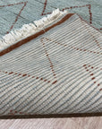 Isla Moroccan Light Blue Hand Knotted Wool Rug, a light blue and wool rug featuring a traditional Moroccan design, situated in a bright, modern living space.