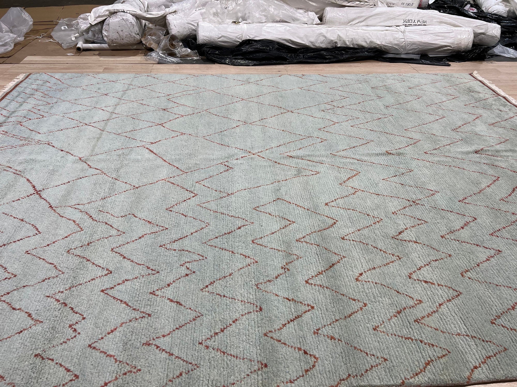 Isla Moroccan Light Blue Hand Knotted Wool Rug, showcasing a serene living room with a light blue wool rug featuring a traditional Moroccan-inspired geometric pattern, grounding a space with a light-toned sofa, wooden furniture, and natural light.