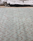 Isla Moroccan Light Blue Hand Knotted Wool Rug, showcasing a serene living room with a light blue wool rug featuring a traditional Moroccan-inspired geometric pattern, grounding a space with a light-toned sofa, wooden furniture, and natural light.