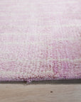Delicate Moroccan Pink Hand Knotted Wool Rug, warm pink hues and intricate geometric patterns create an inviting ambiance in a bright, modern living room setting.