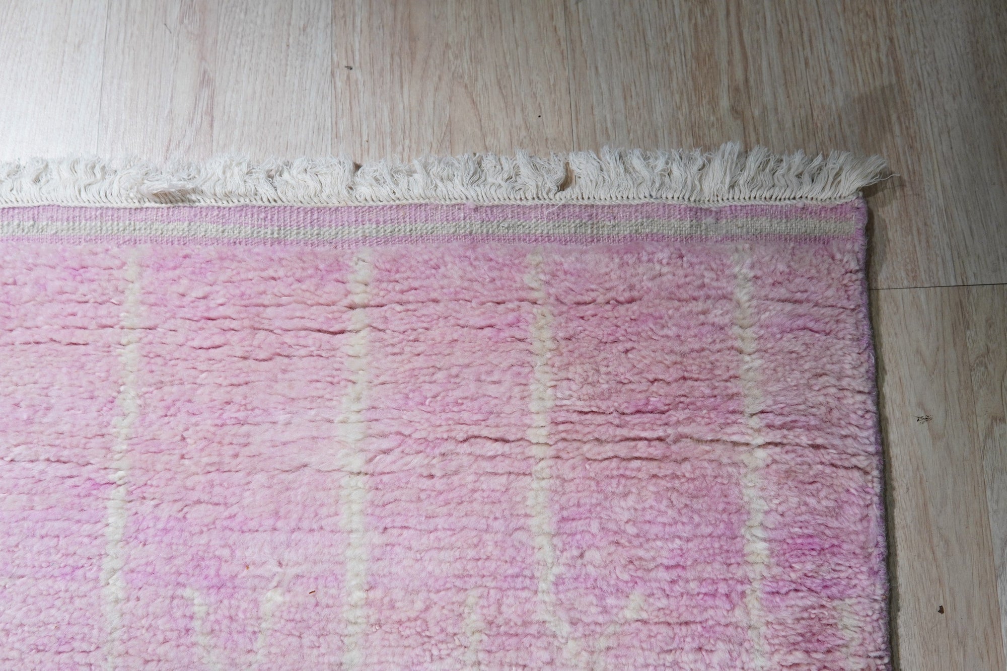 Delicate Moroccan Pink Hand Knotted Wool Rug, a blush-toned wool rug featuring traditional Moroccan motifs, displayed to showcase its texture and craftsmanship.