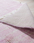 Delicate Moroccan Pink Hand Knotted Wool Rug, seen in a styled interior, its subtle pink hues and hand-knotted texture lending warmth and a touch of bohemian elegance to the space.