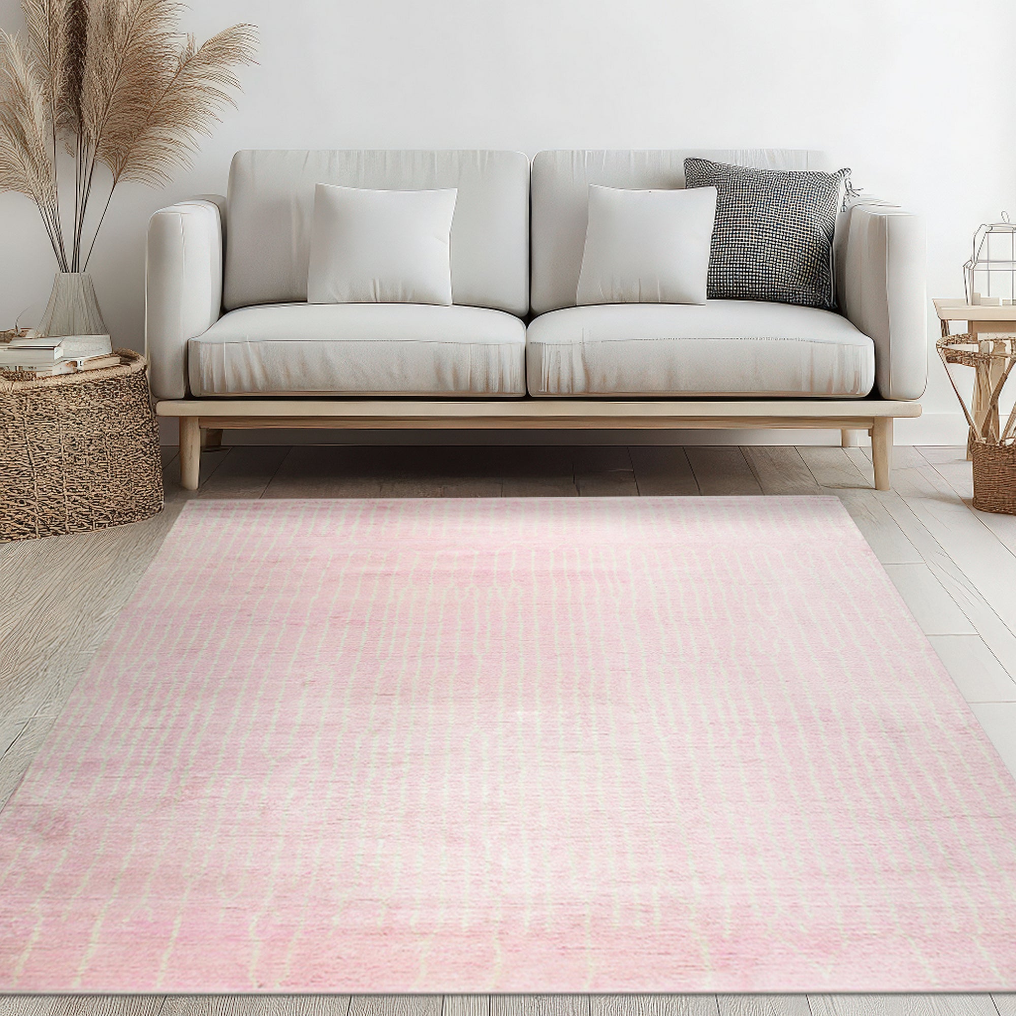 Delicate Moroccan Pink Hand Knotted Wool Rug, a soft pink hand-knotted wool rug featuring geometric patterns, seen on a light wooden floor partially covered by the rug, showing subtle variations in color and texture.