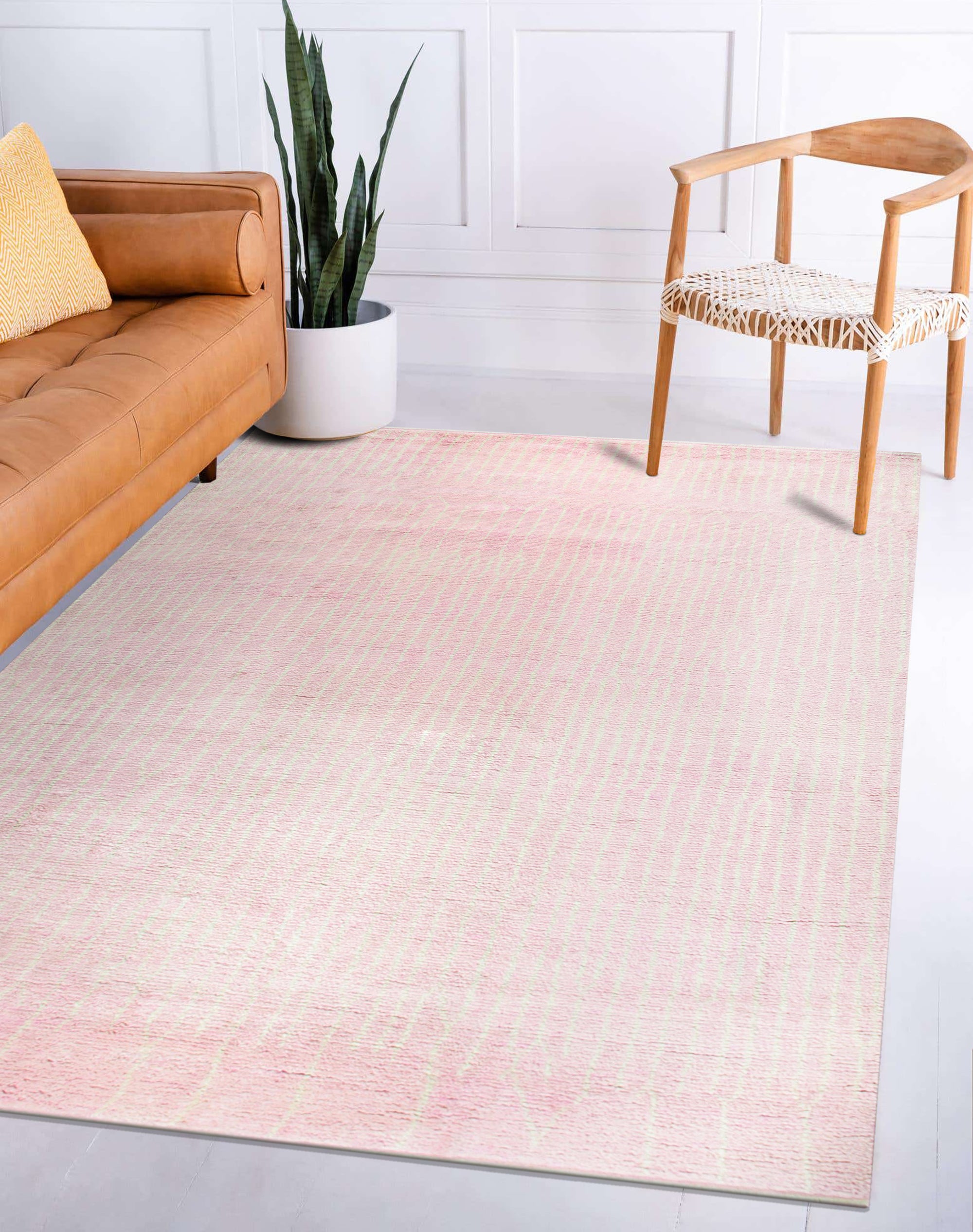 Delicate Moroccan Pink Hand Knotted Wool Rug, a soft pink wool rug with a subtle geometric design, presented on a light wooden floor, its delicate tones creating a serene and inviting atmosphere.