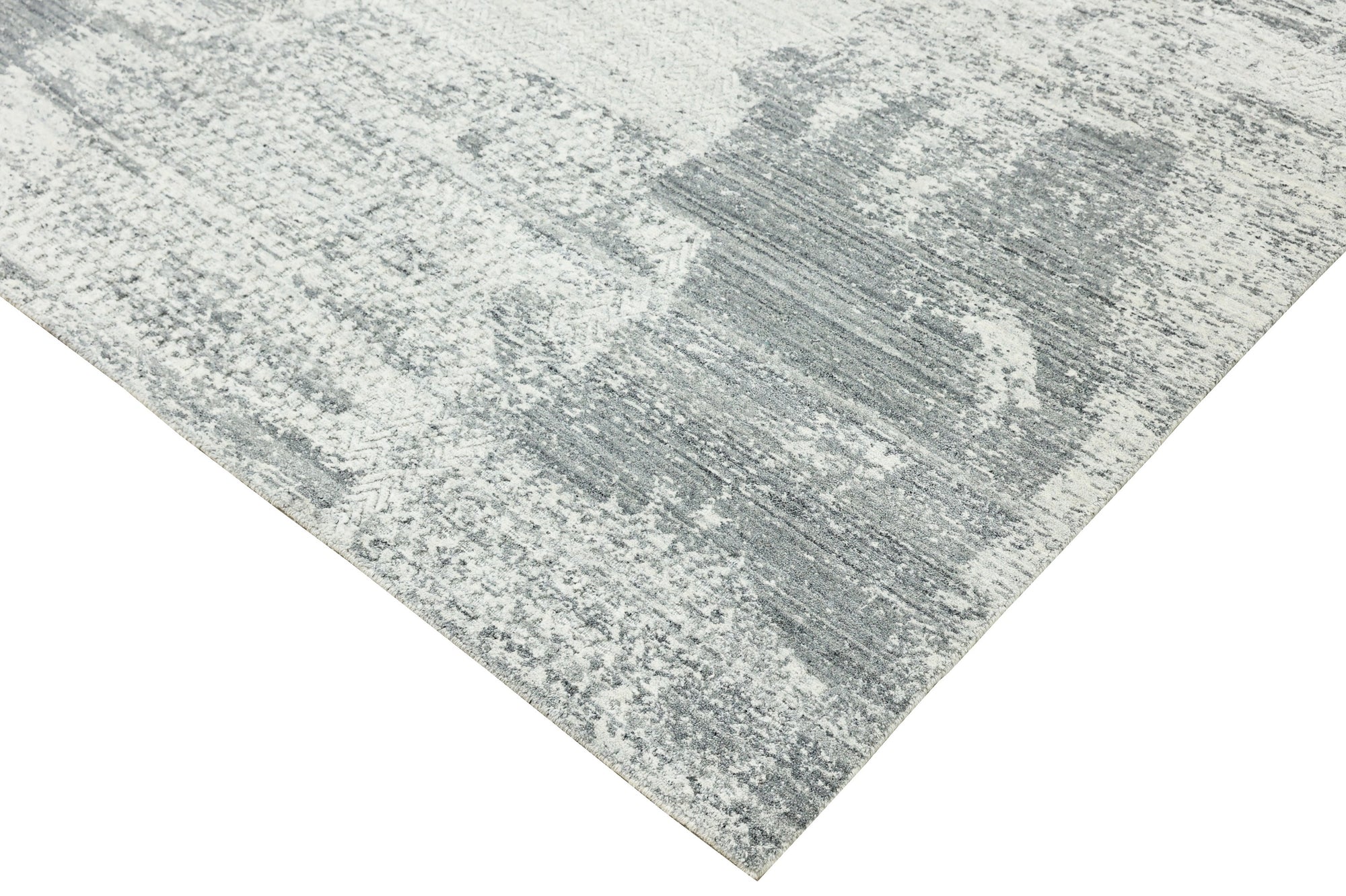 Versatile Freya Gray Handmade Wool Rug, showcasing subtle geometric patterns in varying shades of gray, laid on a light hardwood floor, creating a serene and inviting atmosphere in a modern living space.
