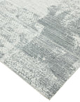 Versatile Freya Gray Handmade Wool Rug, showcasing subtle geometric patterns in varying shades of gray, laid on a light hardwood floor, creating a serene and inviting atmosphere in a modern living space.