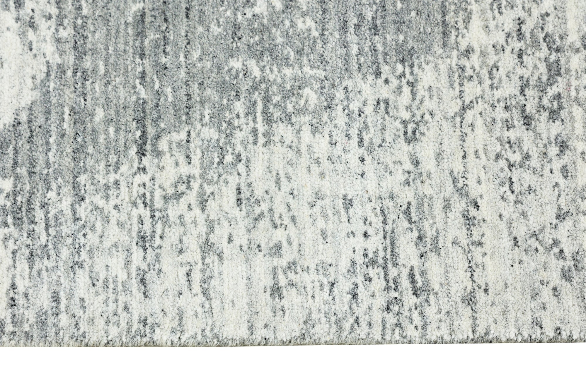 Versatile Freya Gray Handmade Wool Rug, showcasing its subtle, textured gray wool construction and elegant, minimalist design in a softly lit room setting.