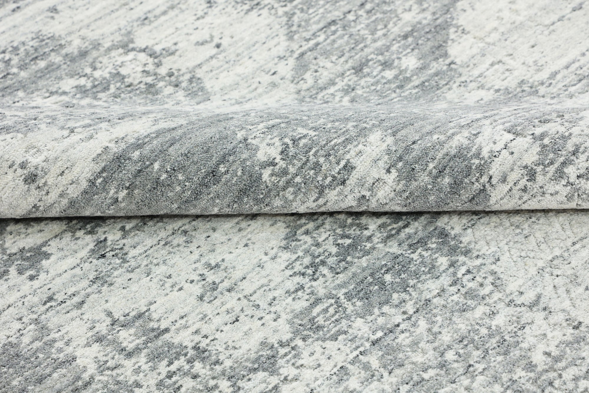 Versatile Freya Gray Handmade Wool Rug, showcasing a minimalist aesthetic in a modern living room setting. The gray wool rug provides a subtle textural element to the space, complementing neutral furniture.