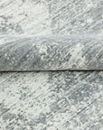 Versatile Freya Gray Handmade Wool Rug, showcasing a minimalist aesthetic in a modern living room setting. The gray wool rug provides a subtle textural element to the space, complementing neutral furniture.