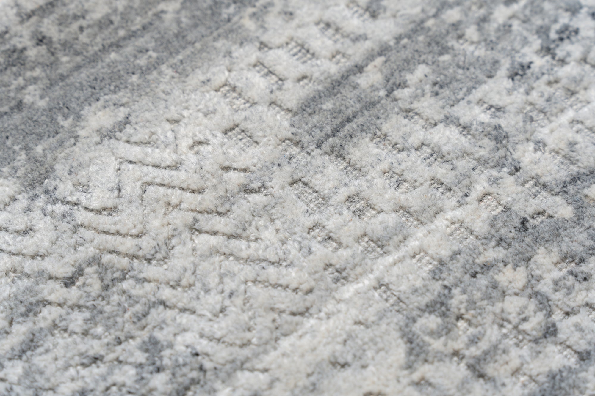 Versatile Freya Gray Handmade Wool Rug, its soft gray tones and subtle, geometric pattern lending a modern yet comforting ambiance to a bright, airy living space.