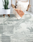 Versatile Freya Gray Handmade Wool Rug displayed on a light hardwood floor, its textured, neutral gray wool fibers offering subtle visual interest; sunlight highlights the handcrafted quality and subtle variations in the pile.