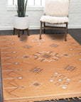 Fiona Penelope Coral Flatweave Rug, showing its intricate flatweave construction and soft coral hues, enriching a warmly lit interior space.