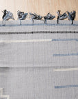 Rustic Penelope Silver Flatweave Rug, showing a cool-toned, distressed geometric pattern in varying shades of silver and grey, lending a vintage, lived-in feel to any space.