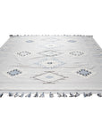 Rustic Penelope Silver Flatweave Rug, its distressed silver tones and flatweave construction lending a relaxed, modern vibe to a bright living space with mid-century modern furniture.