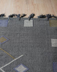 Sleek Inviting Gray Flatweave Rug in a bright living room, its cool gray tones anchoring the space amidst neutral furniture and natural light.
