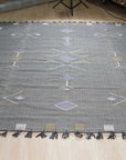 Sleek Inviting Gray Flatweave Rug, soft light highlights the subtle texture of this gray flatweave rug, lending a sense of understated elegance to the room.
