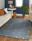 Sleek Inviting Gray Flatweave Rug, anchoring a modern living room; textured gray flatweave contrasts against light wood floors, creating a calming, minimalist space.
