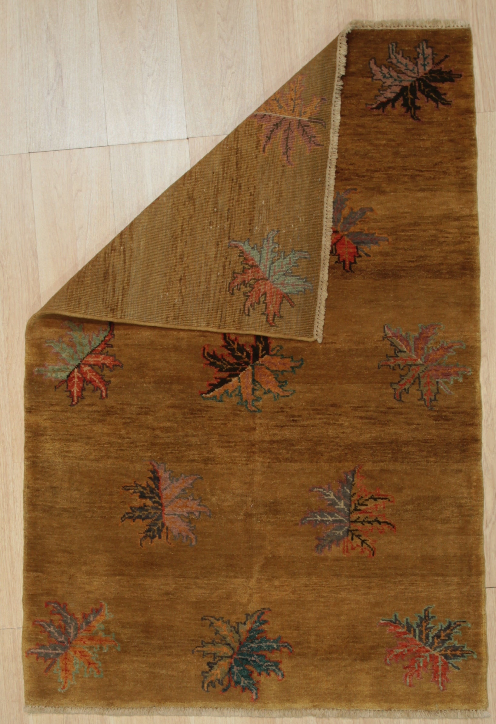 Isla Willow Brown Hand Knotted Wool Rug, a warm brown and cream rug with a subtle, organic pattern, displayed in a brightly lit living room setting with neutral furniture.