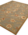 Amara Elegant Blue Machine Made Wool Rug, showcasing intricate floral and geometric patterns in shades of blue and cream, lies flat on a light surface. The rug's detailed texture and machine-made construction are clearly visible.