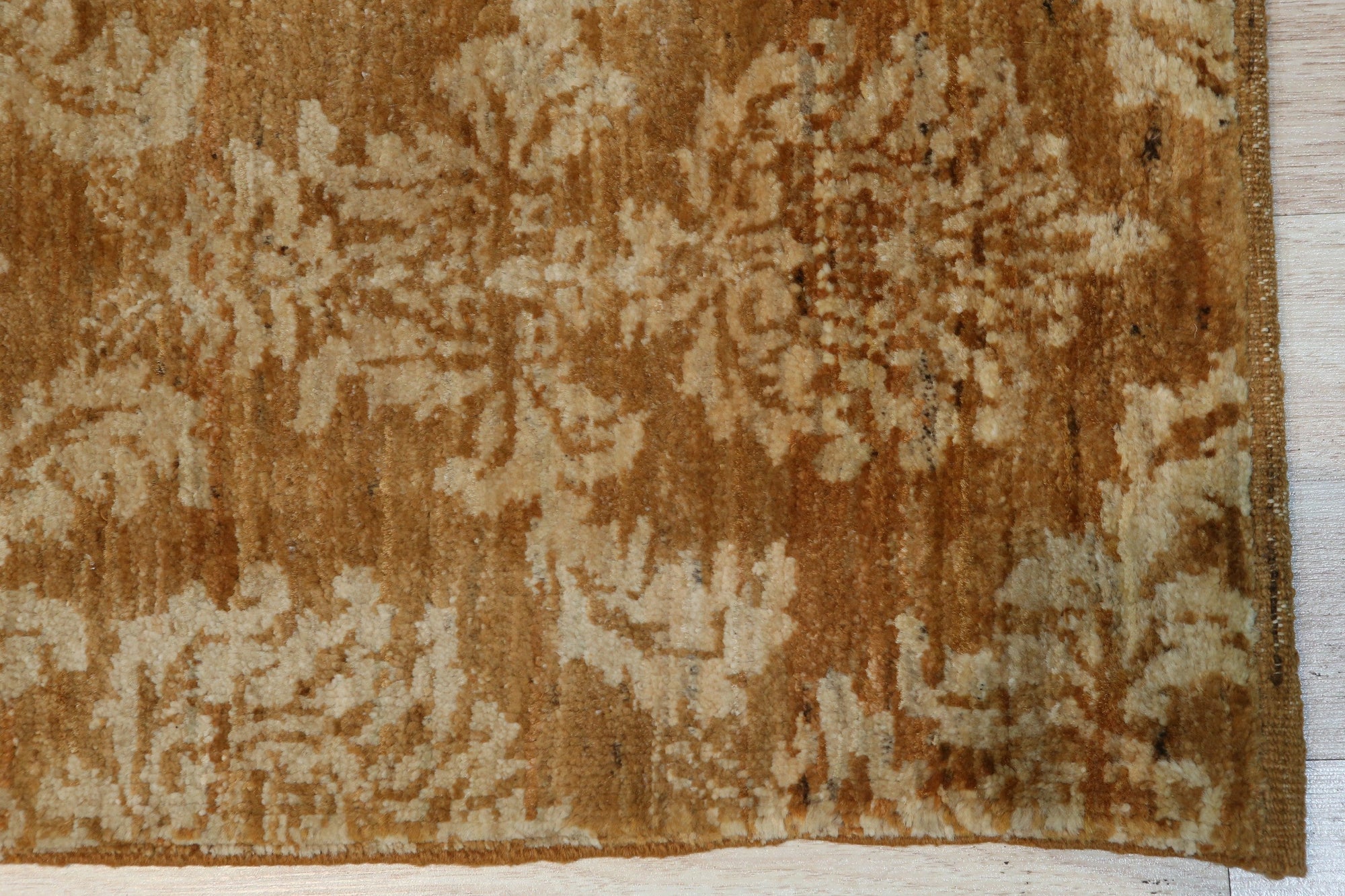 Rustic Bespoke Brown Hand Knotted Afghan Wool Rug, its warm brown tones and hand-knotted texture complement a light hardwood floor, creating a cozy and inviting space.