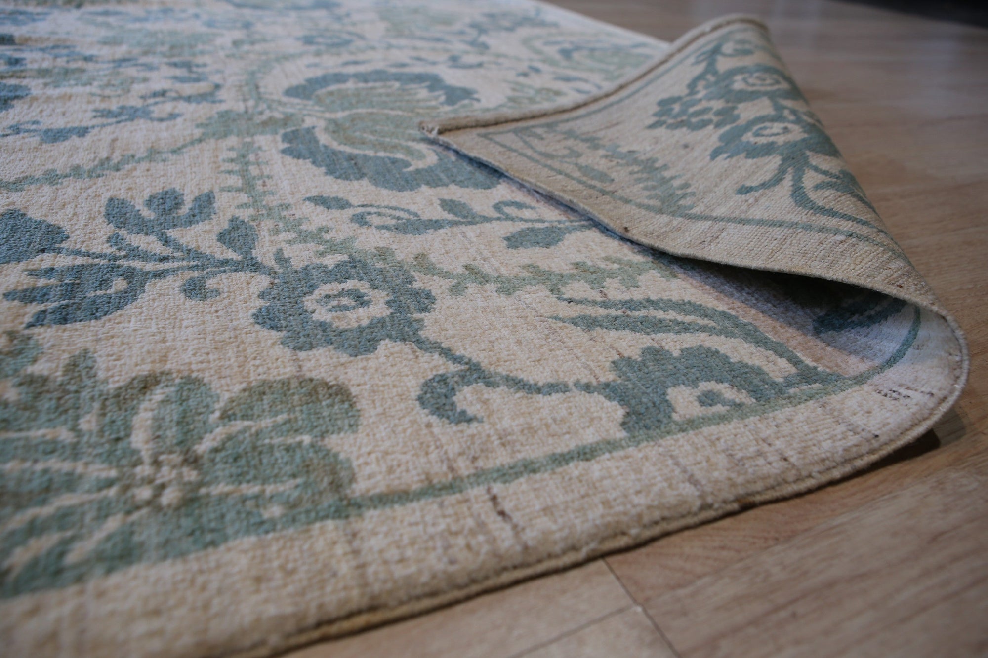 Cassandra Bianca Green Hand Knotted Afghan Wool Rug, showcasing intricate knotwork in shades of green and cream, lending warmth and texture to a stylish living space.