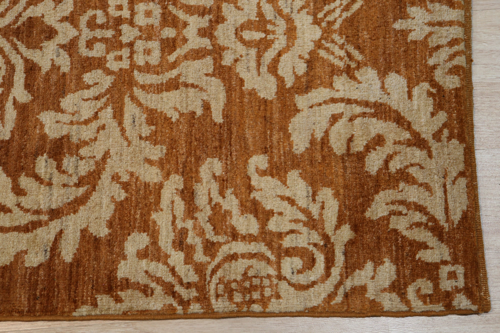 Refined Bespoke Brown Hand Knotted Afghan Wool Rug, a warm brown hand-knotted wool rug with intricate geometric patterns, partially visible showcasing its texture and craftsmanship.