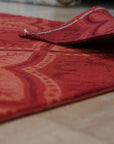 Penelope Maya Red Hand Knotted Afghan Wool Rug, showcasing its vibrant red hues and intricate hand-knotted details, displayed on a light-colored floor in a bright room.